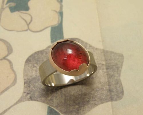 Witgouden ring met rode toermalijn in roodgouden wolk zetting. Oogst goudsmeden Amsterdam.
