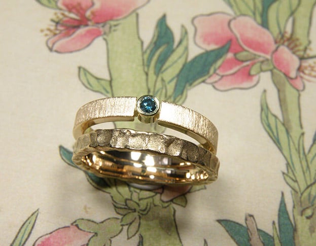 Trouwring Deining en Eenvoud. Aanschuifringen met structuur en ocean blue diamant. Van eigen goud vervaardigd. Wedding rings Swell and Simplicity. Stack rings. made from heirloom gold. With ocean blue diamond. Oogst goldsmith Amsterdam. Edelsmid.
