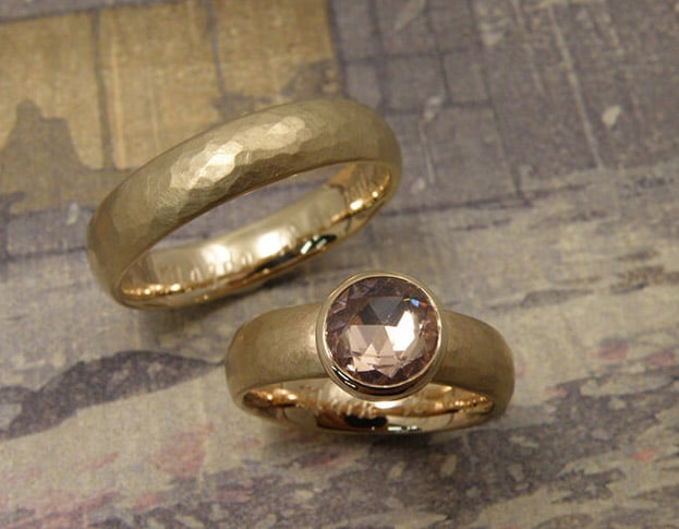 Trouwringen 'Ritme'. Ring met kussen hamerslag van eigen goud vervaardigd met roze saffier. Ring met kussen hamerslag van eigen goud vervaardigd. Wedding rings 'Rhythm'. Ring from heirloom gold with hammering and pink sapphire. Ring from heirloom gold with hammering. Oogst goudsmeden Amsterdam.