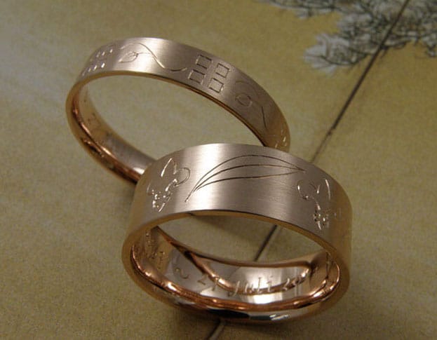 Hand engraved wedding rings 'Lineair'. Rose gold ring with a hand engraving all around of lillies and squares. Created by Oogst.
