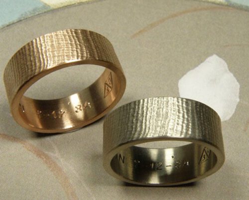 Trouwringen 'Linnen'. Witgouden brede linnenstructuur en roodgouden brede linnenstructuur. Wedding rings 'Linnen'. White golden wider ring with linnen structure and rose golden wider ring with linnen structure. Oogst goudsmeden Amsterdam.