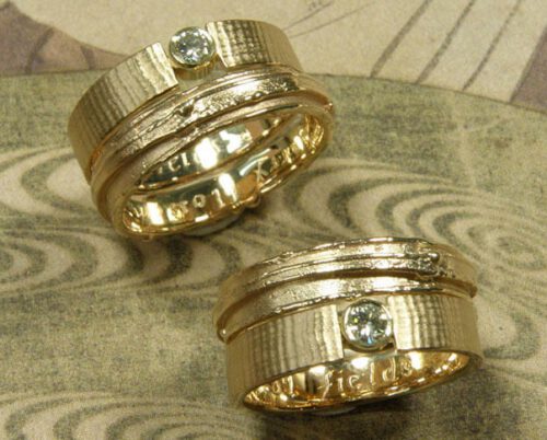 Trouwringen 'Linnen' en 'Erosie'. Linnenstructuur verlovingsring met eigen diamant van oud goud vervaardigd. Structuur trouwring van oud goud vervaardigd. Wedding rings 'Linnen' & 'Erosion'. Engagement ring with linnen structure and heirloom diamond and gold. Weddingring with structure, made from heirloom gold. Uit het Oogst atelier Amsterdam.