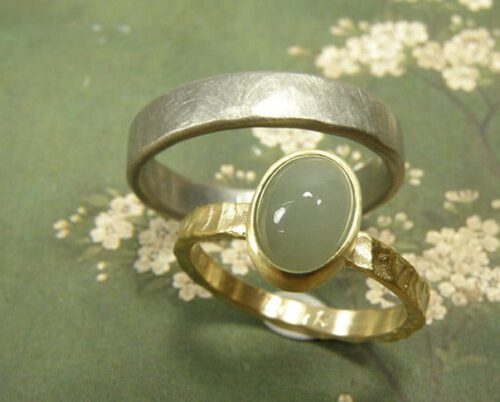 Trouwringen 'Deining' & 'Ritme'. Geelgouden ring met structuur en aquamarijn. Witgouden ring met hamerslag. Wedding rings 'Swell' & 'Rhythm'. Yellow golden ring with structure and aquamarine. White golden ring with hammering. Uit het Oogst atelier Amsterdam.