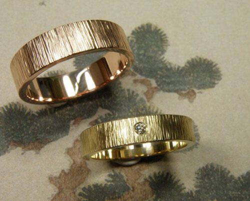Gehamerde trouwringen met spitse hamerslag. Roodgoud en geelgoud met diamant. Handgemaakte trouwringen uit eigen atelier. Oogst goudsmeden in Amsterdam