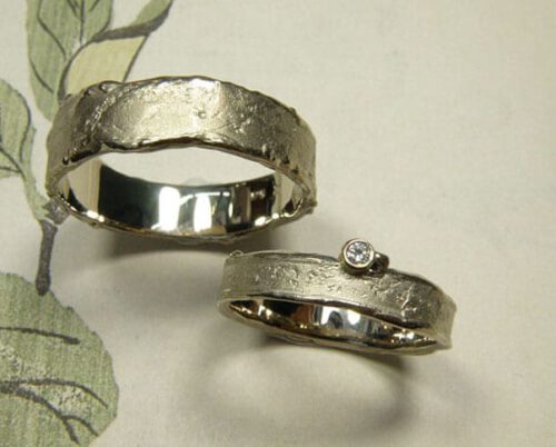Trouwringen 'Erosie'. Witgouden structuur ring met een diamant en witgouden brede structuur ring. Wedding rings 'Erosion'. White golden structure ring with a diamond and a wider white golden ring with structure. Oogst Amsterdam.