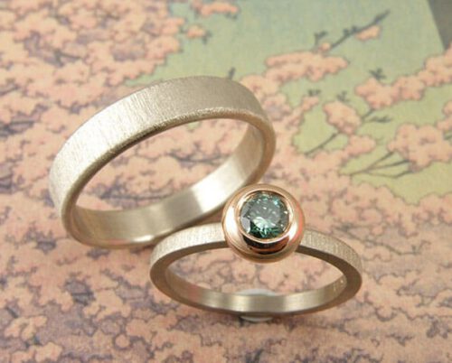 Trouwringen 'Fluweel & Boleet'. Witgouden ring met paraïbagroene diamant in een roodgouden boleet zetting. Witgouden ring. Wedding rings 'Velvet & Boletus'. White golden ring with paraïbagreen diamond. White golden ring. Uit het Oogst Atelier Amsterdam.