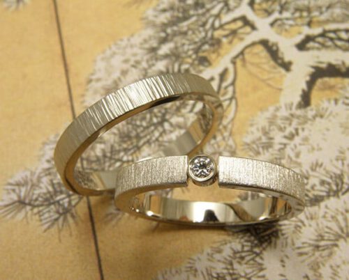 Trouwringen 'Eenvoud' en 'Ritme'. Witgouden ring met diamant en 'fluweel' afwerking. Witgouden ring met hamerslag. Wedding rings 'Simplicity' & 'Rhythm'. White golden ring with diamond and 'velvet' finish. White golden ring with hammering. Oogst goudsmeden Amsterdam.