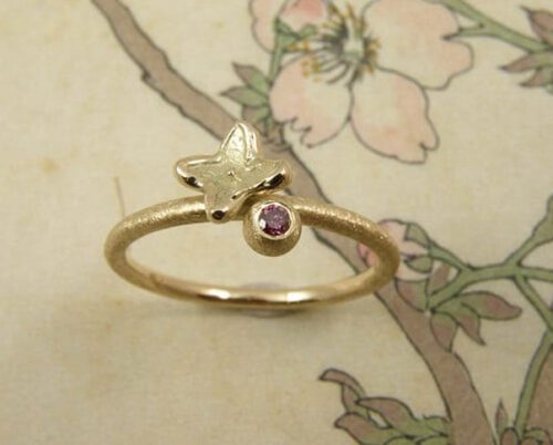 Verlovingsring 'In bloei'. Geelgouden ring met bol, 0,04 crt roze diamant met een bloemetje. Engagement ring 'In bloom'. Yellow golden ring with sphere, 0,04 crt pink diamond and a flower. Oogst goudsmeden Amsterdam.