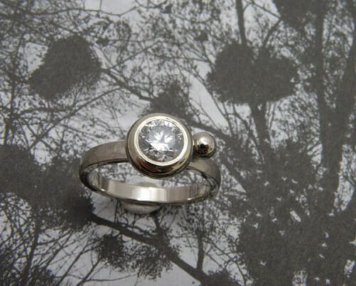 Ring 'Boleet' witgouden hamerslag ring met een eigen diamant uit een erfstuk met een speels bolletje ernaast. Ring ‘Boletus’ white golden ring with hammering, heirloom diamond and a playful sphere. Oogst goudsmeden Amsterdam.