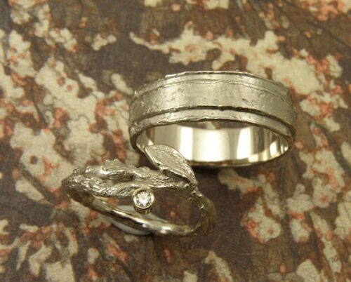 Trouwringen 'Boomgaard' en 'Erosie'. Witgouden ring met takje, blaadje en diamant. Witgouden gelaagde structuur ring. Wedding rings 'Orchard' & 'Erosion'. White golden ring with twig, leaf and diamond. White golden layered ring with structure. Uit het Oogst atelier Amsterdam.