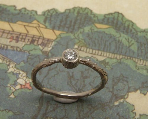 Verlovingsring 'Boomgaard'. Witgouden takje met 0,10 crt diamant. Engagement ring 'Orchard'. White golden twig with 0,10 crt diamond. Oogst goudsmeden Amsterdam.