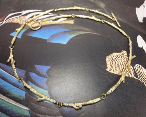 Geelgouden collier 'Boomgaard', verfijnde takjes met blaadjes en sprankelende diamant. Oogst goudsmid Amsterdam atelier. Handgemaakte sieraden Colliers