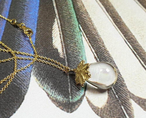 geboortesieraad 'Esdoorn' Geelgouden hanger met blaadje en druppelvormige bergkristal * maatwerk baargoud cadeau uit het Oogst goudsmid atelier. Birth present. Yellow gold pendant with quartz and a leaf.
