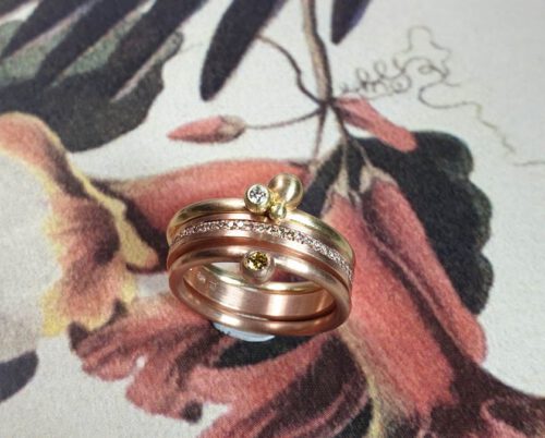 Rose gold Eternity ring with diamonds pavé set all around with yellow gold and rose gold Berries rings with diamonds. Stacking rings. Oogst Amsterdam