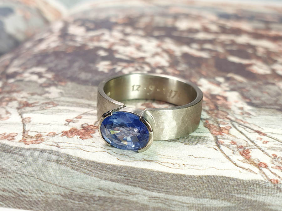 Blog about sapphire. White gold mens ring with a hammered finish and an oval cut sapphire. Design by Oogst studio in Amsterdam.