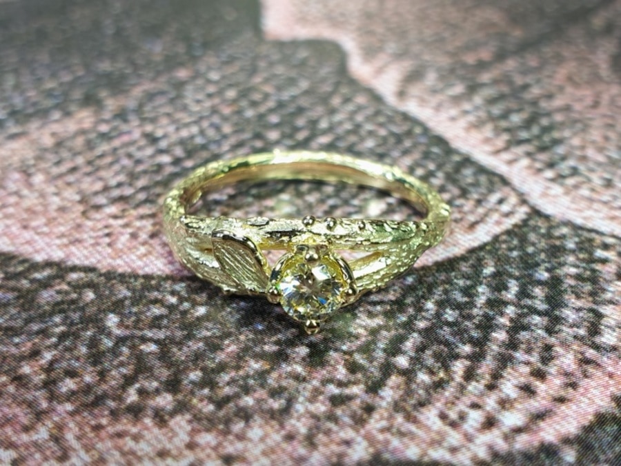 Verlovingsring geelgouden takje met diamant cape in chaton. Boomgaard. Engagement ring yellow gold twig with diamond cape. orchard. Design by Oogst Goudsmid Amsterdam