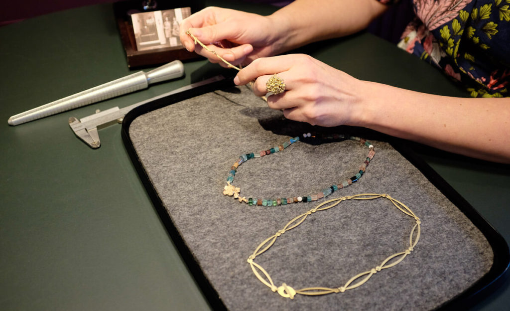 Sieraden tonen aan de klant in de Oogst winkel.