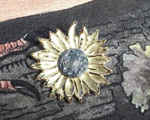 Geelgouden speld Zonnebloem met zilveren pitten kern. Maatwerk sieraad van Oogst goudsmid atelier in Amsterdam.