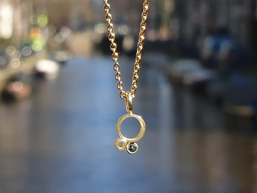 Geelgouden hanger 'Lichtpuntje' met blauwe spinel. Yellow gold pendant 'Ray of light' with a blue spinel. Oogst goudsmid Amsterdam