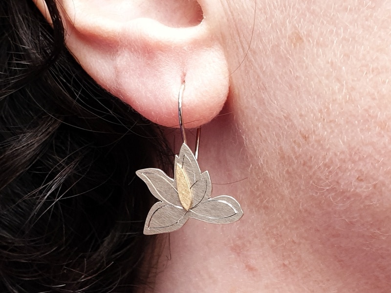 Witgouden Magnolia oorsieraden met handgravure en geelgouden details. White gold magnolia earrings with hand engraving and yellow gold details. Oogst goudsmid Amsterdam
