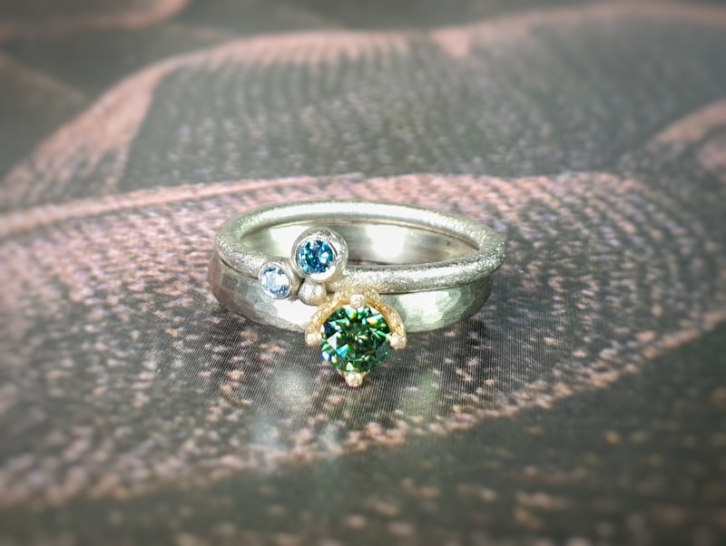 Witgouden 'Ritme' ring met groene diamant. Witgouden 'Bessen' ring met blauwe diamanten. Oogst edelsmid Amsterdam