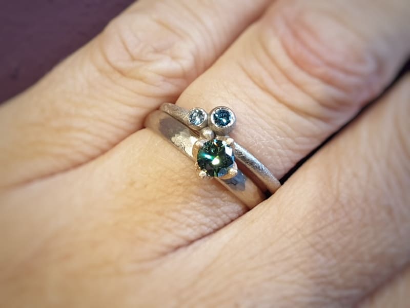 Witgouden 'Ritme' ring met groene diamant. Witgouden 'Bessen' ring met blauwe diamanten.. Aanschuifringen. Oogst Amsterdam