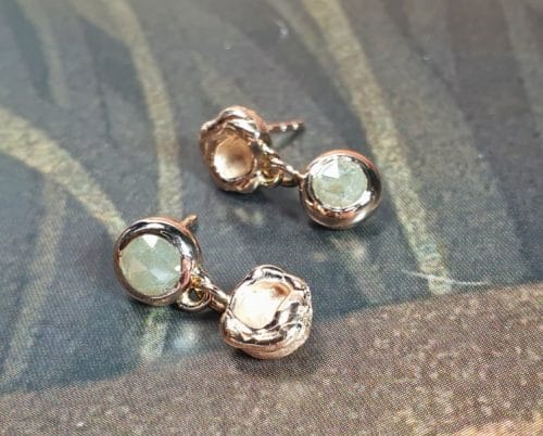 Roodgouden 'Perzik' oorbellen met roosgeslepen diamanten. Oogst goudsmid Amsterdam Geelgouden 'Zwammen' armband met handgravure en toermalijn kristal. Ontwerp van Oogst goudsmid in Amsterdam uit de Amorf vs Kristallijn collectie.