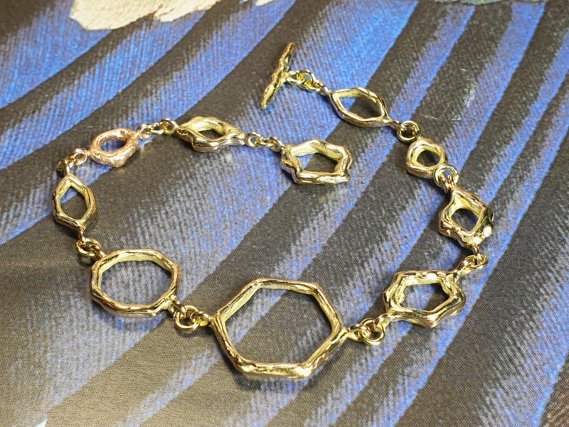 Geelgouden armband 'Amorf Hoekig' met een roodgouden schakel.Unieke handgemaakte sieraden. Ontwerp van Oogst goudsmid in Amsterdam uit de Amorf vs Kristallijn collectie. Handgemaakte sieraden Armbanden