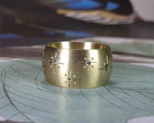 Geelgouden ring 'Eenvoud' met blauwe en groene diamanten. Ontwerp van Oogst goudsmeden in Amsterdam