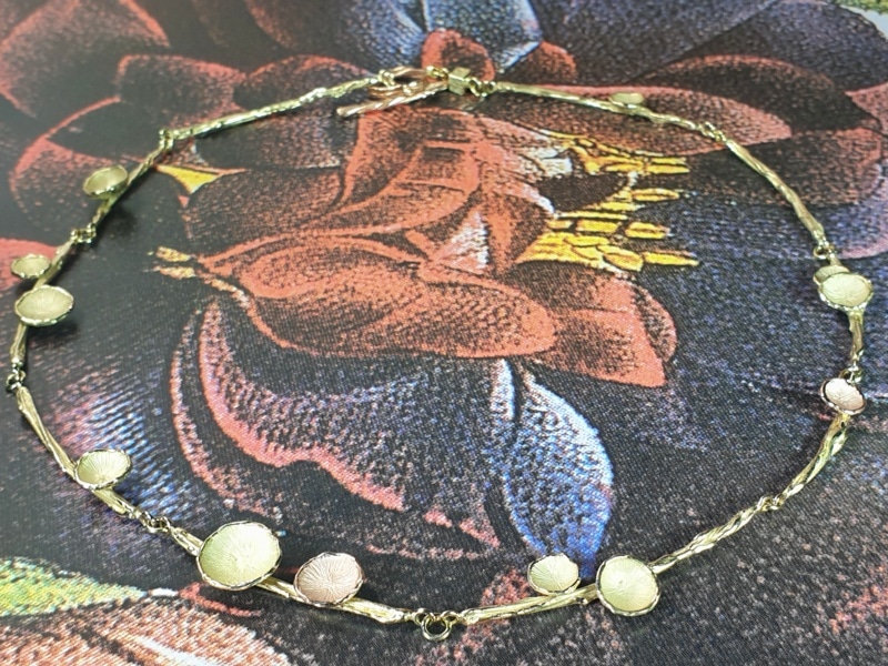 Geelgouden collier 'Twist' met zwammetjes in roodgoud en geelgoud. Ontwerp van Oogst goudsmid in Amsterdam uit de Amorf vs Kristallijn collectie.
