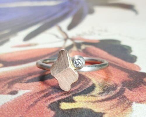 Witgouden ring 'Vouwen' met roodgouden element en bes met 0,03 ct diamant. Ontwerp van Oogst goudsmid in Amsterdam uit de Amorf vs Kristallijn collectie.