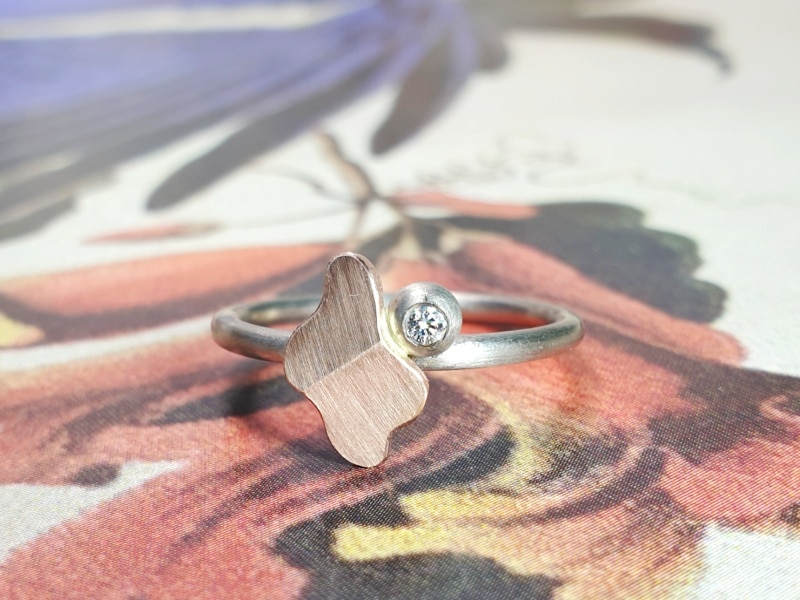 Witgouden ring 'Vouwen' met roodgouden element en bes met 0,03 ct diamant. Ontwerp van Oogst goudsmid in Amsterdam uit de Amorf vs Kristallijn collectie.