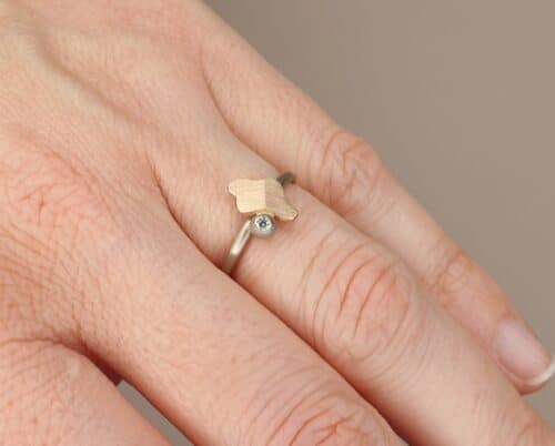Witgouden ring 'Vouwen' met roodgouden element en bes met 0,03 ct diamant. Ontwerp van Oogst goudsmid in Amsterdam uit de Amorf vs Kristallijn collectie.