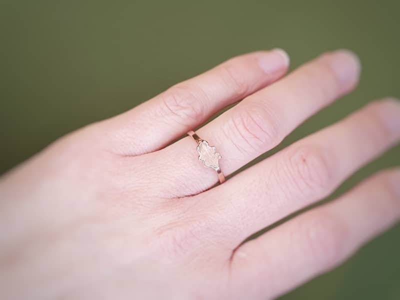Rose gold 'Oak' ring with a delicate leaf. Seen on the finger. Designed by Oogst goldsmith studio in Amsterdam.