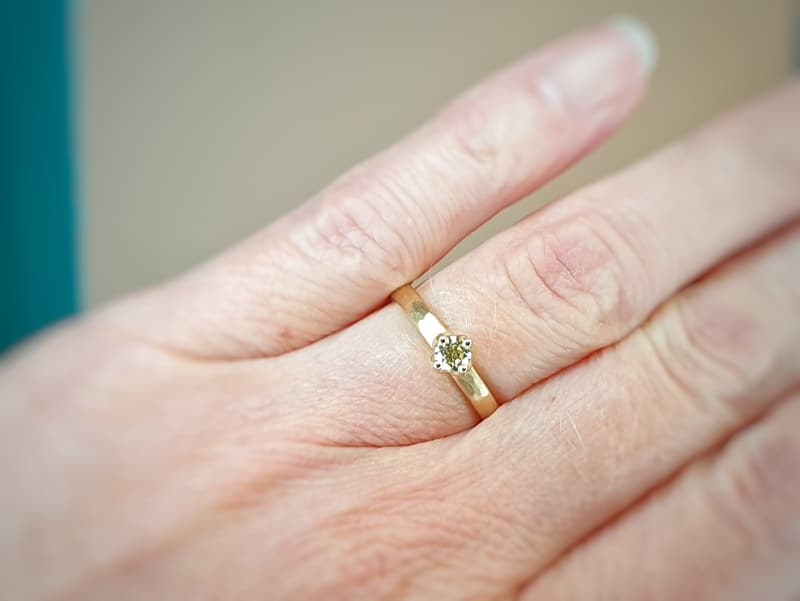 Verlovingsring roségouden ring met hamerslag en 0,23 crt briljant geslepen diamant cape. Oogst goudsmid Amsterdam.