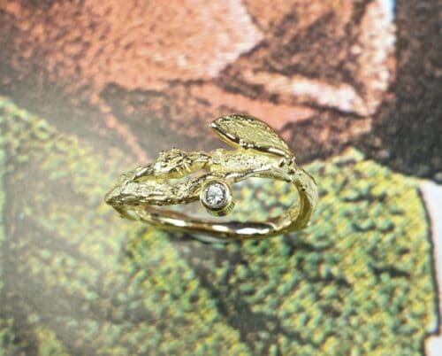 Geelgouden ring 'Boomgaard' weelderige takjes met blaadje en diamant.