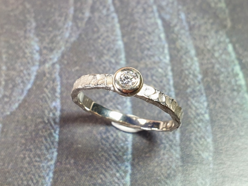 Engagement ring 'Swell'. White golden ring with texture and 0,10 ct diamond. Made at Oogst studio.