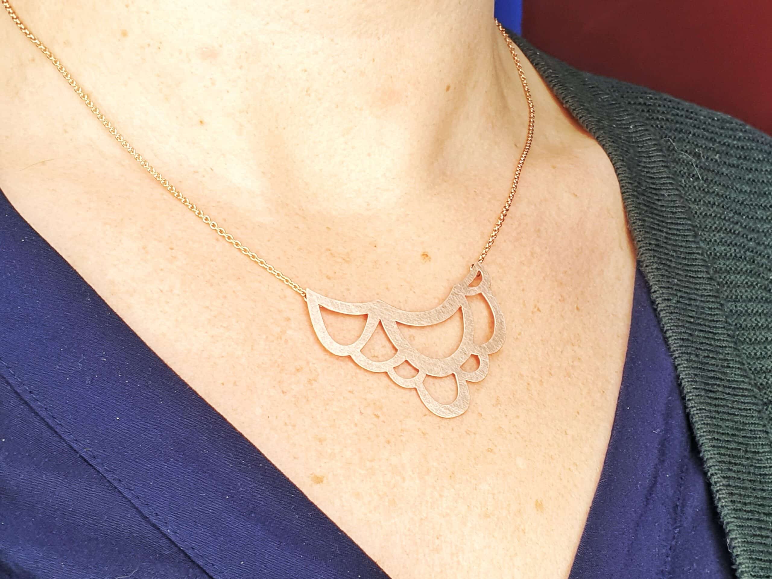 Rose gold 'Linear' necklace with a loops element. Standout jewel. Created by goldsmith studio Oogst. Seen on a model.