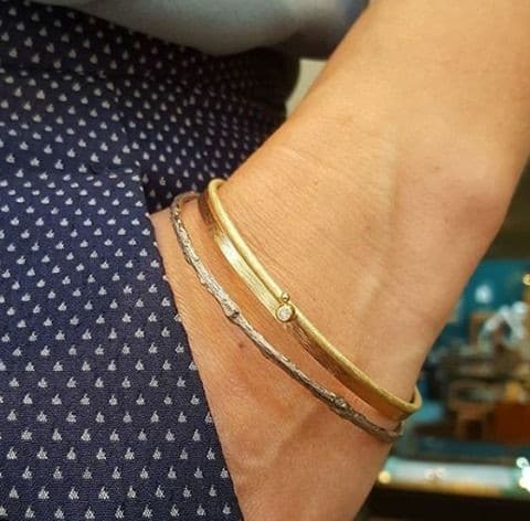 Handgemaakte armbanden. Witgouden 'Boomgaard' rinkelband. Roodgouden 'ritme' armband en geelgouden 'bessen' armband samen gedragen.. Uit het Oogst atelier Amsterdam.