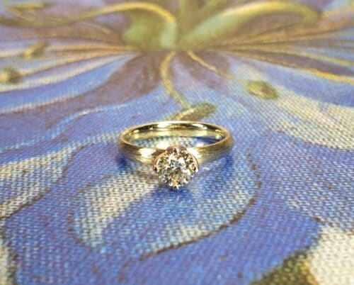 Geelgouden 'Ritme' verlovingsring met 0,52 ct cape diamant en spitse hamerslag. Ontwerp van Oogst Goudsmeden.