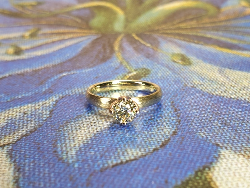 Geelgouden 'Ritme' verlovingsring met 0,52 ct cape diamant en spitse hamerslag. Ontwerp van Oogst Goudsmeden.