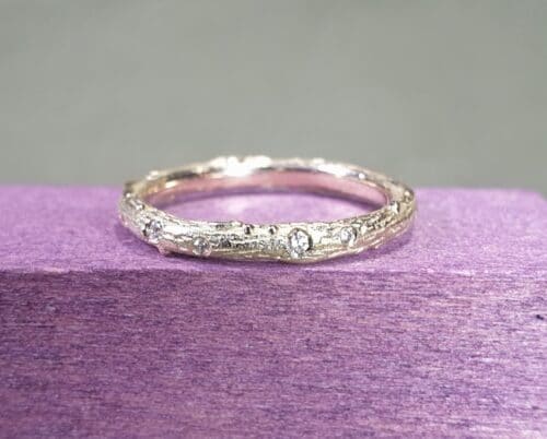 Geelgouden verlovingsring met diamanten rondom speels verdeeld gezet. Ontwerp van Oogst Sieraden in Amsterdam