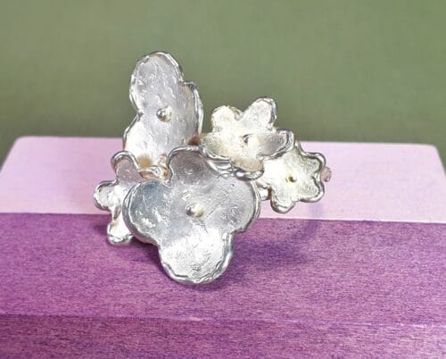 Zilveren ring met bloemen. Handgemaakte ring uit de 'In Bloei' serie van Oogst Sieraden in Amsterdam.
