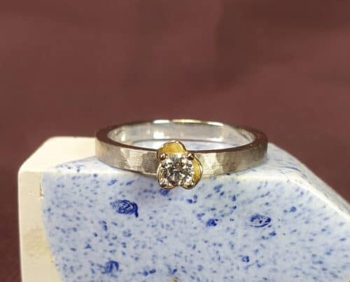 Diamantring uit de Ritme serie van Oogst Sieraden in Amsterdam. Witgouden ring met diamant en geelgouden bloem.