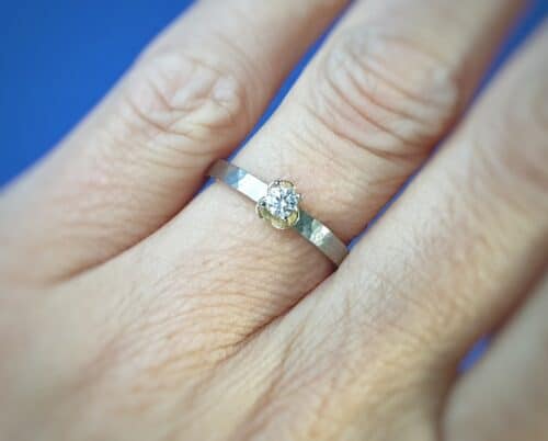 Diamantring uit de Ritme serie van Oogst Sieraden in Amsterdam. Witgouden ring met diamant en geelgouden bloem.