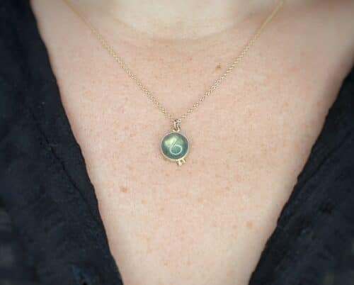 Geelgouden hanger 'Besjes' met ronde labradoriet. Ontwerp van Oogst Sieraden in Amsterdam