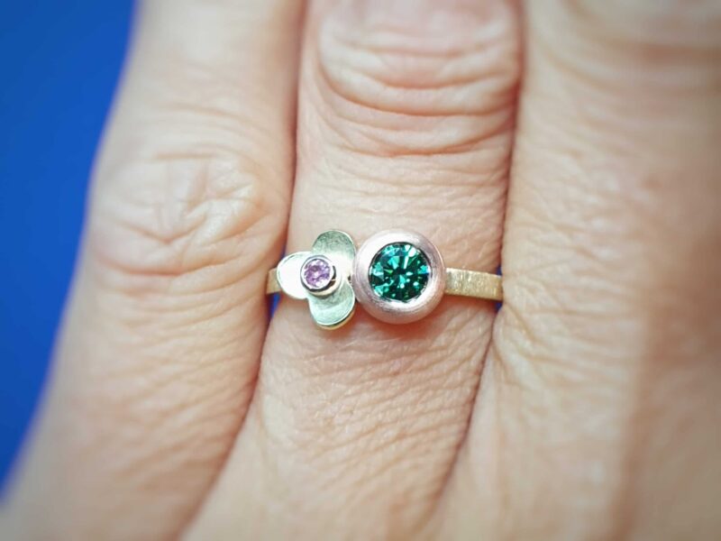 Yellow gold Boletus ring with a green diamond and a pink sapphire in a flower. Playful one-of-a-kind design by Oogst Jewellery.
