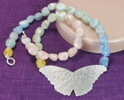 Zilveren Vlinder met beryl in natuurlijk kleurverloop collier. Ontwerp van Oogst Sieraden in Amsterdam