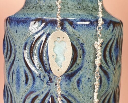 Zilveren Bessen collier met een larimar ornament. Lange ketting met kleurrijk detail. Ontwerp van Oogst Sieraden in Amsterdam.