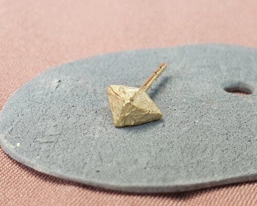 Geelgouden oorbel 'Kristallen'. Stoere hoekige vorm. Enkele oorbel. Ontwerp van oogst Sieraden in Amsterdam.
